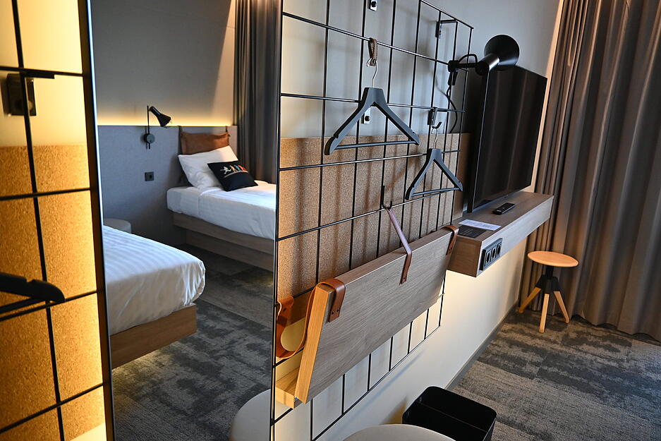 Eher spartanisch eingerichtet sind die Zimmer. Statt Schrank gibt es etwa ein Gitter zum Aufhängen der Kleidung.