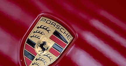 Licht reflektiert sich auf dem Logo des Autobauers Porsche.