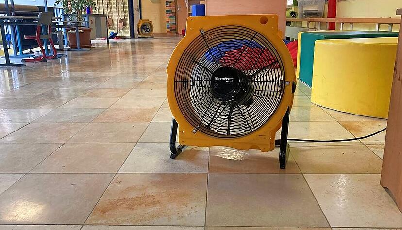 Die warme Luft wird mit Hilfe von Bauventilatoren in den Schulr&auml;umen verteilt.