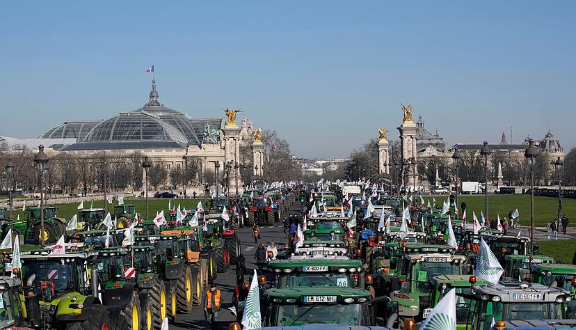 Traktoren parken vor dem Museum Grand Palais (l). Franz&ouml;sische Landwirte st&ouml;ren mit Hunderten von Traktoren den Verkehr in Paris, um gegen ein EU-Pestizidverbot zu protestieren.