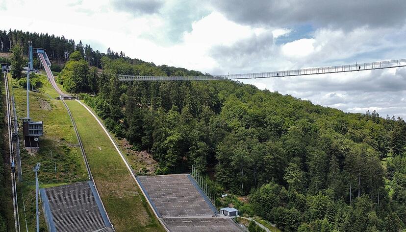Alte und neue Attraktion nebeneinander: Der Skywalk f&uuml;hrt von der M&uuml;hlenkopfschanze auf der einen Seite des Tals hin&uuml;ber zum Musenberg auf der anderen Seite.
