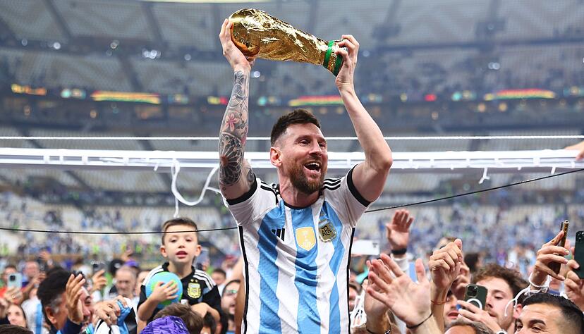 Argentiniens Lionel Messi l&auml;sst sich mit dem Weltmeisterpokal feiern.