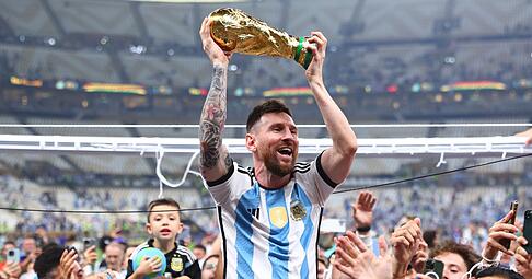 Argentiniens Lionel Messi l&auml;sst sich mit dem Weltmeisterpokal feiern.