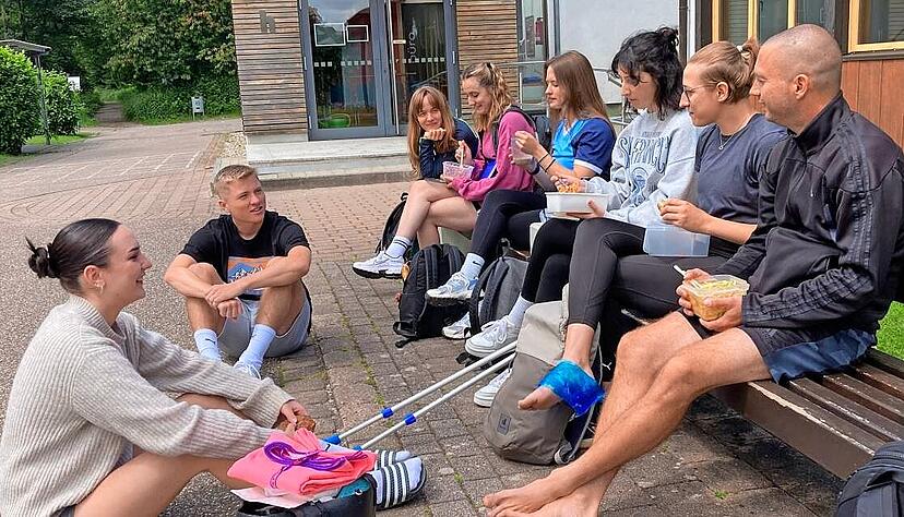 Svenja (links) ist mit ihren 18 Jahren die J&uuml;ngste dieser Gruppe, Robin (rechts) mit 41 Jahren der &Auml;lteste. Die Sportsch&uuml;ler verbringen die Mittagspause in der Sonne.