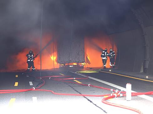 Rettungskr&auml;fte schlagen an  der Einfahrt zum Engelbergtunnel Flammen entgegen.
