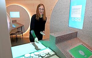 Julia Schlenker, eine der Ausstellungsmacherinnen, demonstriert, wie ein KI-System mithilfe der Besucher Gedichte verfasst. Viele Informationen kommen per QR-Code direkt aufs Smartphone, etwa an der Klangstation.