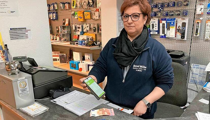 Keine Extra-Technik n&ouml;tig: Angelika M&uuml;ller vom Elektrofachgesch&auml;ft M&uuml;ller zeigt, wie man die Gutscheinkarte per Handyeingabe aufl&auml;dt.