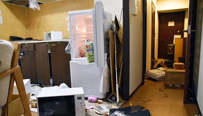Möbel und Elektrogeräte liegen nach dem  Erdbeben verstreut in einer Wohnung in Fukushima.