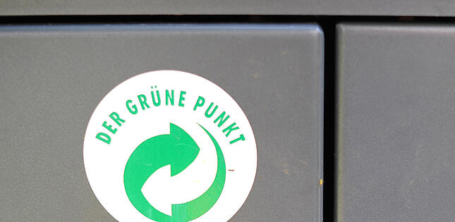 ARCHIV - Ein Aufkleber mit dem Logo «Der Grüne Punkt» klebt am 23.06.2013 auf einem Mülleimer in Hamburg. Die Recyclingfirma Remondis aus Nordrhein-Westfalen setzt ihren Expansionskurs fort. (zu dpa «Recyclingkonzern Remondis übernimmt dänische Müllabfuhr-Firma» vom 25.01.2018) Foto: Marcus Brandt/dpa +++ dpa-Bildfunk +++