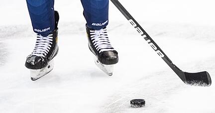 Ein Eishockeyspieler spielt den Puck.
