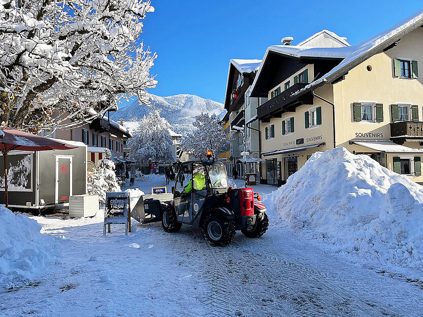Ein Radlader befreit eine Straße in Garmisch-Partenkirchen von den Schneemassen. Ein ungewöhnlich starker Wintereinbruch bescherte Bayern Schnee, Eis und Verkehrschaos. Am Sonntag entspannte sich die Lage schrittweise und Sonntagsausflügler genießen die sonnigen Seiten des Winters.