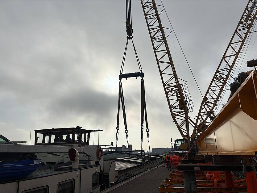Nach längerer Verzögerung beginnt am späten Vormittag der Kran damit, den Trafo vom Binnenschiff zu heben. Nach längerer Verzögerung beginnt am späten Vormittag der Kran damit, den Trafo vom Binnenschiff zu heben.