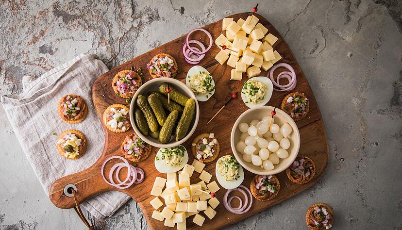Eine typische niederl&auml;ndische Borrel-Platte mit Filet Americain auf Crackern mit Zwiebel, Ei oder Kapern. Dazu werden K&auml;sew&uuml;rfel, Cornichons, Silberzwiebeln und gef&uuml;llte Eier mit Schnittlauch serviert.