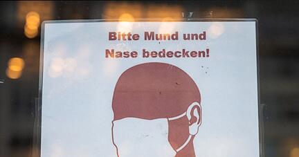 Ein Schild weist in Hamburg auf das Tragen einer Maske hin.