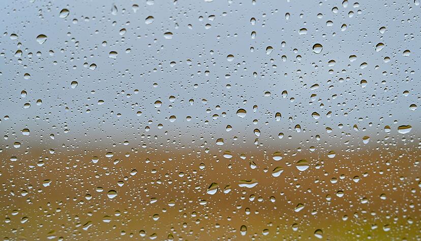 Wassertropfen sind an einer Autoscheibe nach einem Regenschauer zu sehen.