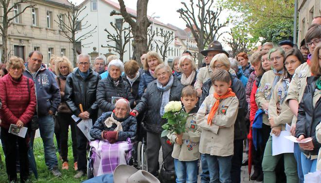 Hedwig Megerle (im Rollstuhl) und Marianne Wunder (hinter ihr) verfolgen mit vielen anderen, wie Gunter Demnig in der Karlsvorstadt 37 acht Stolpersteine verlegt.