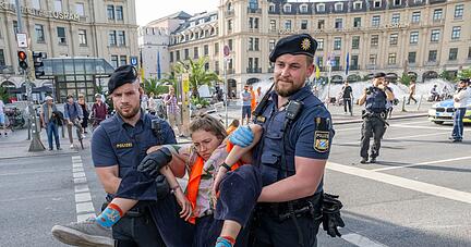 Polizisten tragen auf der Kreuzung am Stachus in der M&uuml;nchener Innenstadt Aktivisten der Letzten Generation weg. Ihre Aktionen werden teilweise verboten.