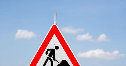 Ein Schild weist auf eine Baustelle hin.