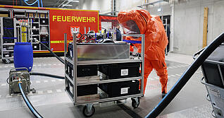So könnte ein Gefahrgut-Einsatz aussehen: Aus einem beschädigten Container wird mit Spezialpumpe und -schlauch giftige Flüssigkeit abgepumpt. Die Einsatzkräfte benötigen einen chemischen Schutzanzug.