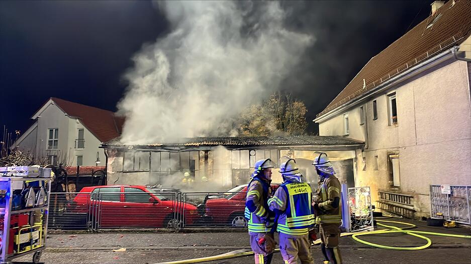 Einsatzkräfte bekämpfen Flammen auf einem Betriebshof. Einsatzkräfte bekämpfen Flammen auf einem Betriebshof.