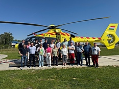 Vertreter der Kreisstadt K&uuml;nzelsau besuchen die ungarische Partnerstadt Marcali und festigen die langj&auml;hrige Verbindung beider St&auml;dte. Die Gruppe steht hier vor einem Hubschrauber der Luftrettungsbasis Marcali.