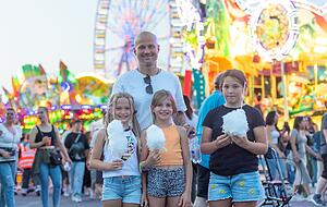 Greta, Lilli und Marie (v.l.) ziehen eine Zuckerwatte vor, spendiert von Rainer Schürg.