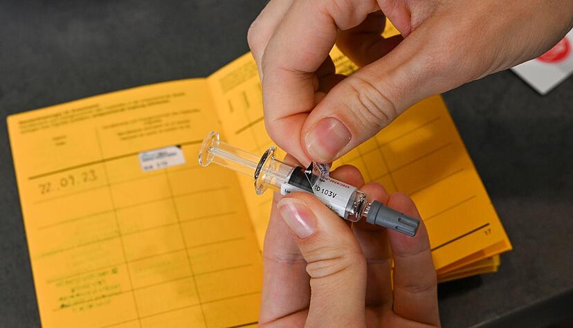 Ein Etikettenaufkleber mit der Chargen-Bezeichnung einer Grippeschutzimpfung wird von der Spritze abgezogen und in einen Impfpass eingeklebt. (Archivbild)