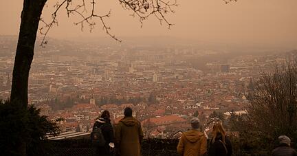 06.02.2021, Baden-W&uuml;rttemberg, Stuttgart: Gelb-r&ouml;tlich erscheint der Himmel &uuml;ber der Innenstadt von einem Aussichtspunkt aus, weil in der Luft Saharastaub sein soll. Foto: Marijan Murat/dpa +++ dpa-Bildfunk +++