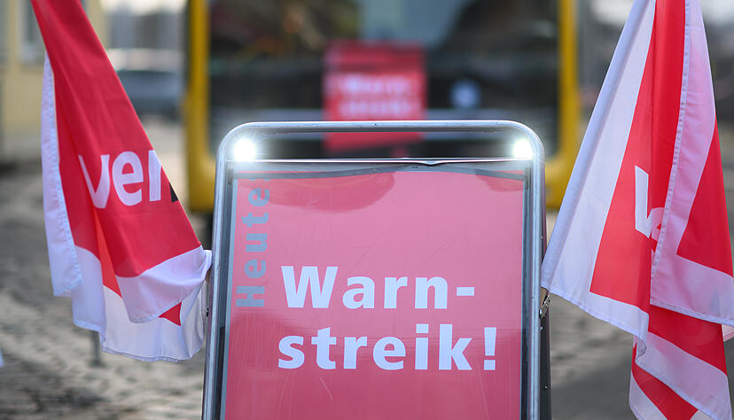 ARCHIV - 02.02.2024, Sachsen, Dresden: Ein Schild "Warnstreik" steht vor einem Bus der Dresdner Verkehrsbetriebe (DVB) während des Warnstreiks im öffentlichen Nahverkehr im Betriebshof Trachenberge.  (zu dpa: «Warnstreik im Nahverkehr beendet - Verdi berät über weiteres Vorgehen») Foto: Robert Michael/dpa +++ dpa-Bildfunk +++