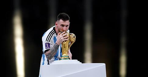 Argentiniens Nationalspieler Lionel Messi k&uuml;sst die WM-Troph&auml;e nach dem Sieg im Endspiel.