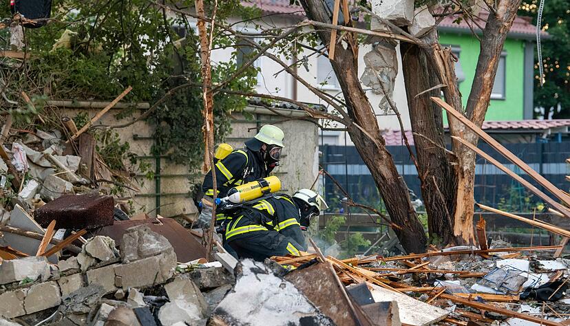Feuerwehrleute in den Trümmern des zerstörten Hauses Feuerwehrleute in den Trümmern des zerstörten Hauses