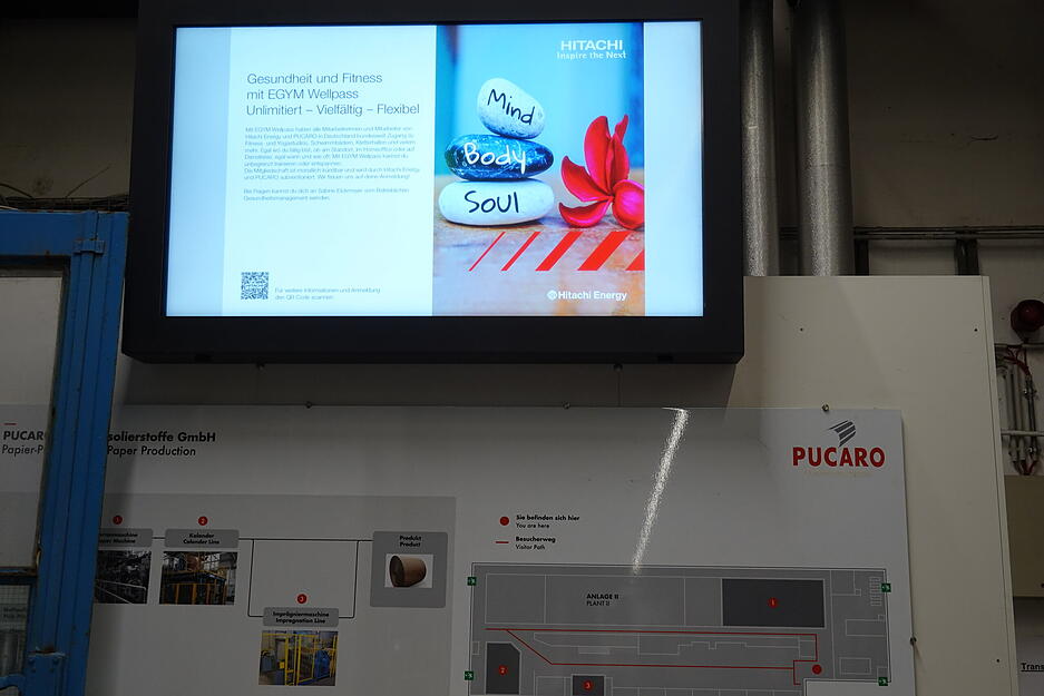 Der neue Mutterkonzern heißt Hitachi. Viel verändert hat sich nicht dadurch, doch auf den Info-Monitoren werden die neuen Benefits des Unternehmens erläutert.