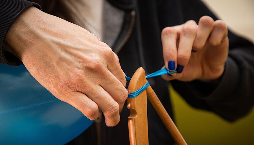 Schritt 5: Das verknotete Ende vom Kleiderb&uuml;gel ziehen, bis der Ballon abrutscht.