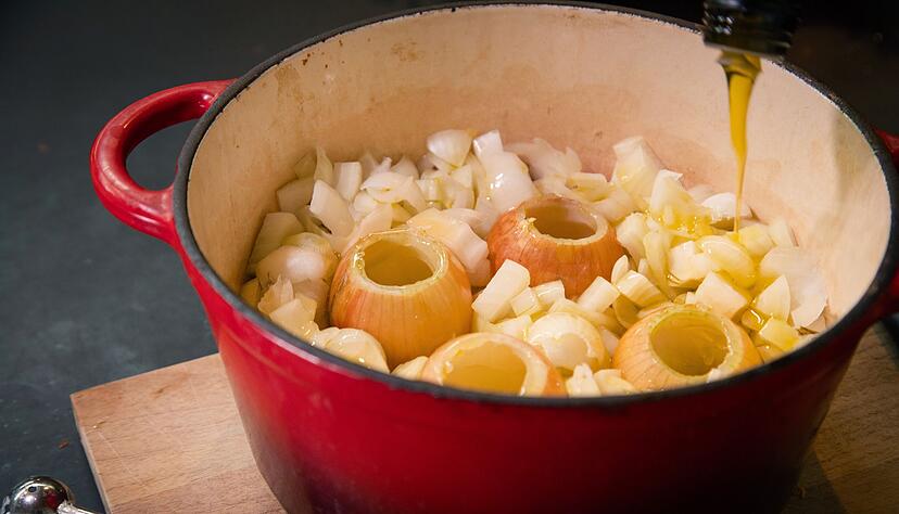 Ausgehöhlte und geschnittene Zwiebeln kommen zusammen mit Olivenöl zum langsamen Garen, dem sogenannten Confieren, für 1,5 Stunden in den Topf. Ausgehöhlte und geschnittene Zwiebeln kommen zusammen mit Olivenöl zum langsamen Garen, dem sogenannten Confieren, für 1,5 Stunden in den Topf.