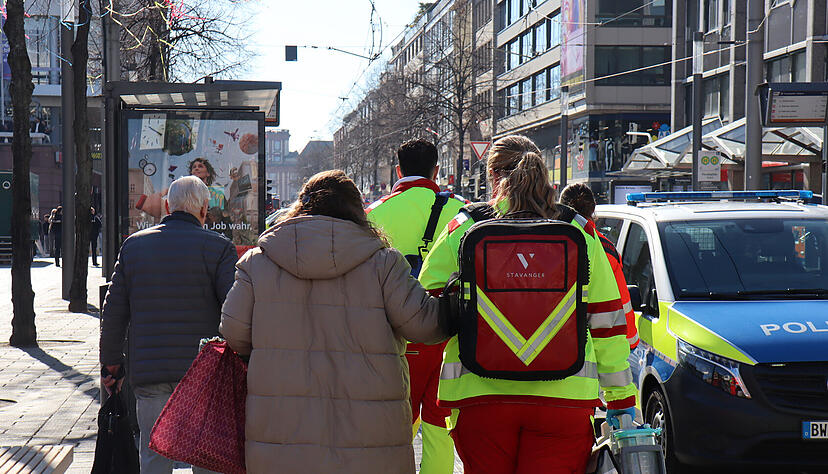 Rettungskräfte begleiten Menschen bei einem Großeinsatz der Polizei in der Innenstadt von Mannheim.
