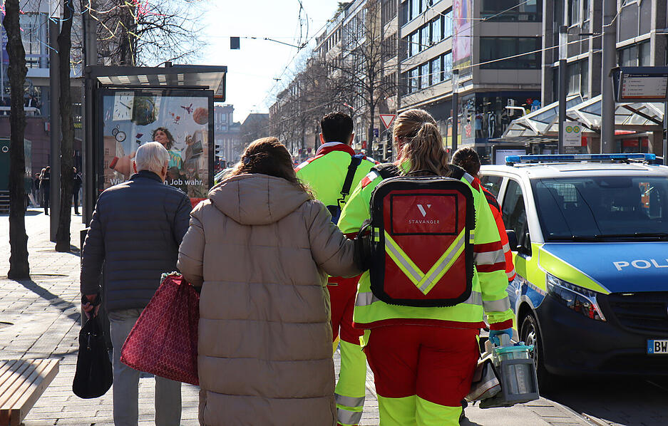 Rettungskräfte begleiten Menschen bei einem Großeinsatz der Polizei in der Innenstadt von Mannheim.