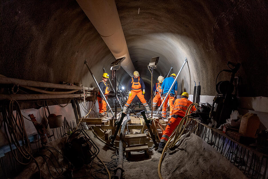 Arbeiten im und am Fluchtstollen: Mit einem Schlauch wird der Beton an Ort und Stelle gebracht.