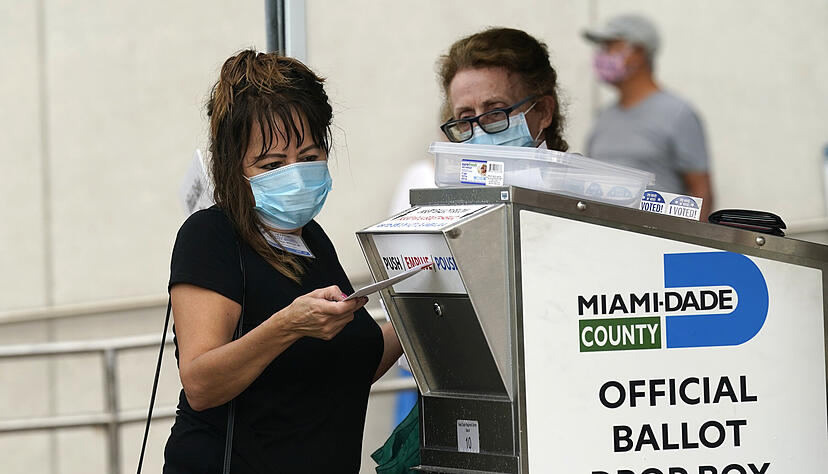 Eine Wahlhelferin wirft einen Briefwahl-Stimmzettel in eine Wahlurne bei der Stimmabgabe f&uuml;r die Pr&auml;sidentschaftswahlen. Foto: Lynne Sladky/AP/dpa