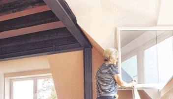 Uschi Kühner befreit im Seminarraum die Fenster vom Baudreck.
