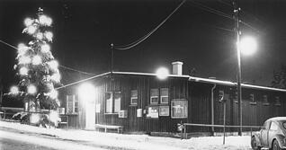 Eine Schneedecke und der beleuchtete Weihnachtsbaum sorgten im Jahr 1960 f&uuml;r weihnachtliche Stimmung vor dem Fl&uuml;chtlingslager Weinsberg.