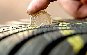 Mit einer 1-Euro-M&uuml;nze l&auml;sst sich das Reifenprofil ganz einfach kontrollieren. Der goldene Rand sollte unten nicht aus dem Profil herausragen.