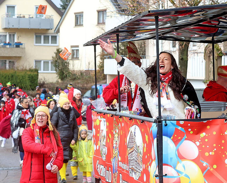 S&uuml;&szlig;igkeiten und kleine Geschenke fliegen beim Karnevalsumzug in die Menge.