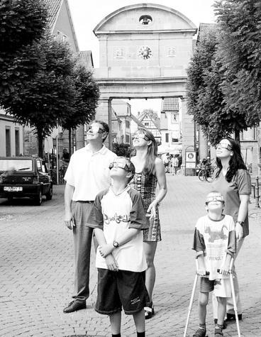 Öhringen: Familie mit Sofi-Schutzbrillen riskiert einen Blick nach oben. Öhringen: Familie mit Sofi-Schutzbrillen riskiert einen Blick nach oben.