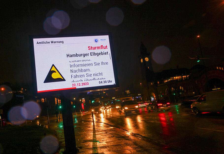 Auf einer Werbetafel an den Landungsbrücken im hamburger Hafen ist eine Amtliche Sturmflutwarnung zu sehen. Für die deutsche Nordseeküste sowie Hamburg bestand am Freitag die Gefahr einer schweren Sturmflut.