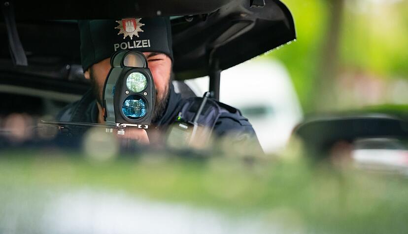 Ein Polizist kontrolliert mit einem Messgerät die Geschwindigkeit von Fahrzeugen. Die Beamten nehmen in den nächsten Tagen wieder verstärkt Raser ins Visier.