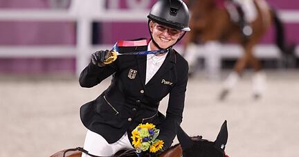 Mit der Goldmedaille um den Hals reitet Julia Krajewski nach der Siegerehrung auf Amande de B`Neville eine Ehrenrunde.