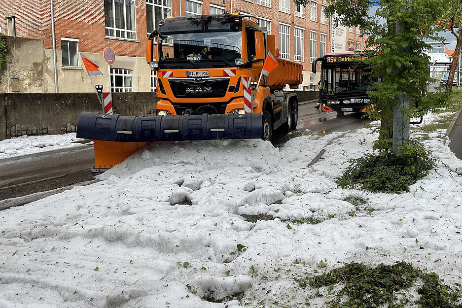Die Technischen Betriebsdienste rücken mit Schneepflügen an um den Hagel von der Straße zu räumen.
