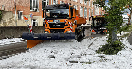 Die Technischen Betriebsdienste rücken mit Schneepflügen an um den Hagel von der Straße zu räumen.