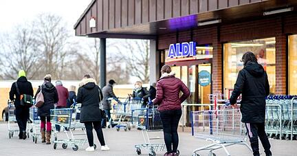 Zahlreiche Kunden warten auf die Öffnung einer Filiale von Aldi in Hannover.