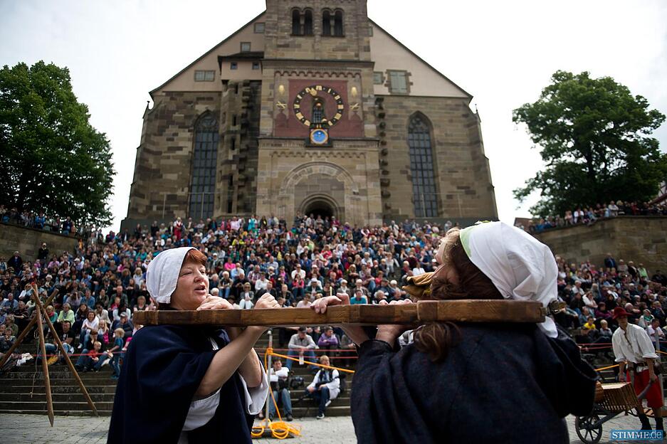Zwei streitende Marktfrauen stehen sich in einer Doppel-Halsgeige, einer mittelalterlichen Form der Strafe, am 24.05.2015 beim Salzsiederfest in Schw&auml;bisch-Hall (Baden-W&uuml;rttemberg) auf dem Marktplatz gegen&uuml;ber. &Uuml;ber Jahrhunderte produzierten die Salzsieder Salz - das "wei&szlig;e Gold des Mittelalters". Durch den damit verbundenen Handel wurde die Stadt wohlhabend. Seit dem 14. Jahrhundert ist in Schw&auml;bisch Hall das Salzsiederfest &uuml;berliefert. Foto: Daniel Naupold/dpa +++(c) dpa - Bildfunk+++